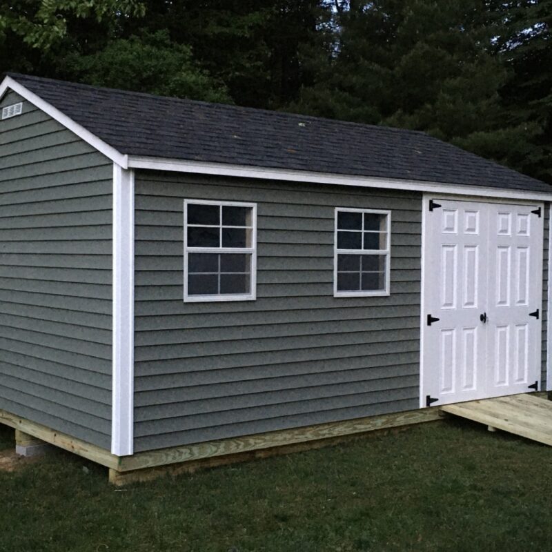 "Backyard showing a well-placed storage shed with sunlight, clear access path, and good drainage." The site's slope, soil conditions, available sunlight, overhanging tree branches can be important factors when locating your shed.